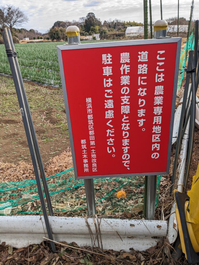 東方公園近くの駐車禁止看板画像。
「ここは農業専用地区内の道路になります。農作業の支障となりますので、駐車はご遠慮ください」とかかれている。